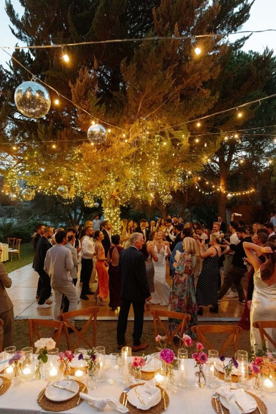 Işıklı ağaçlar altında düğün yemeği